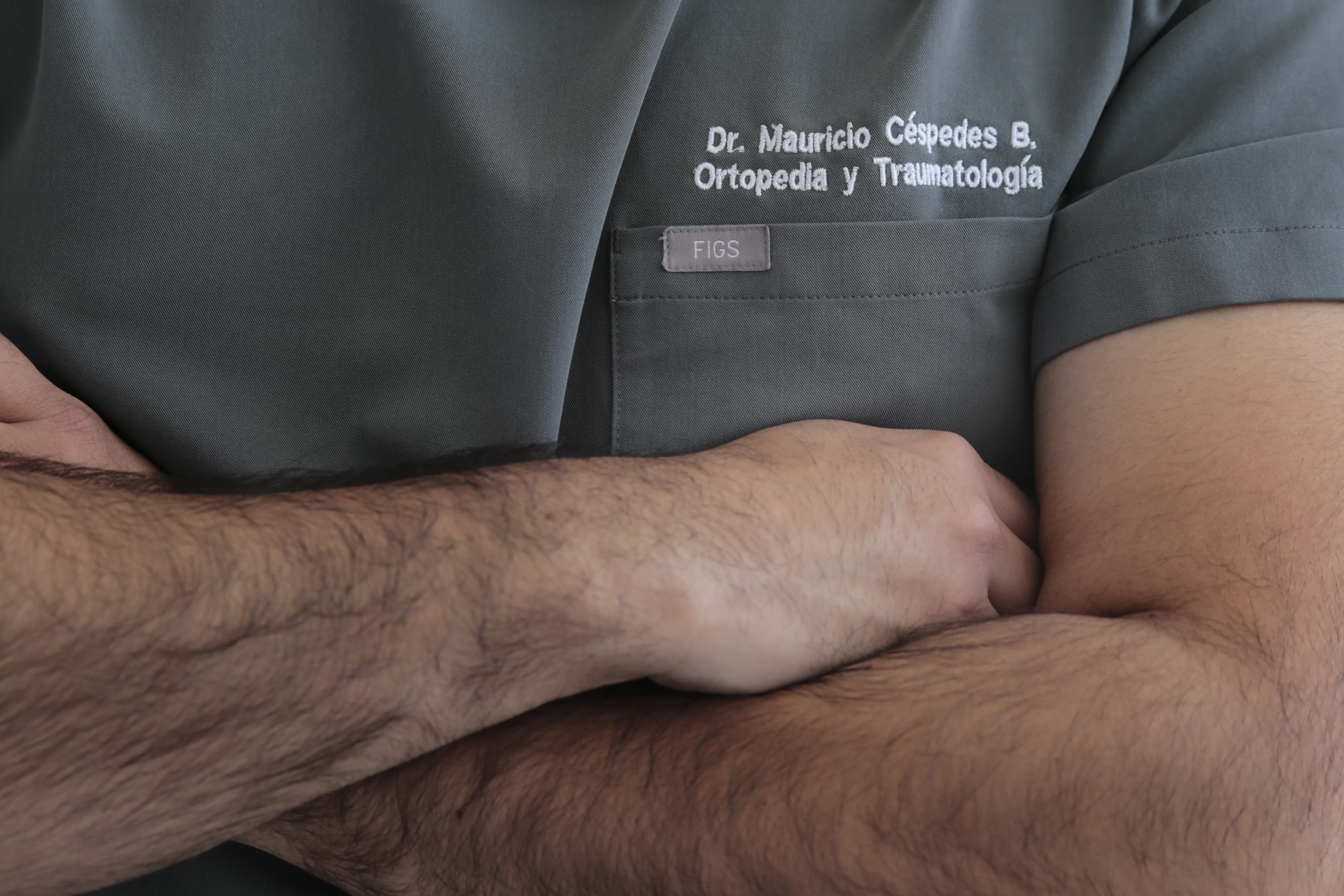 Detalle del uniforme clínico del Dr. Mauricio Céspedes con bordado de su especialidad