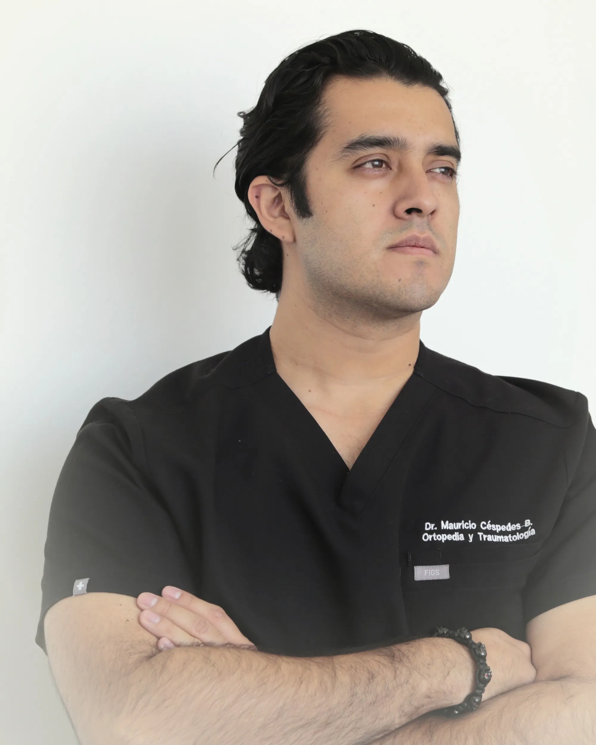 Retrato del Dr. Mauricio Céspedes, ortopedista y traumatólogo en Puebla, con filipina quirúrgica en su consultorio