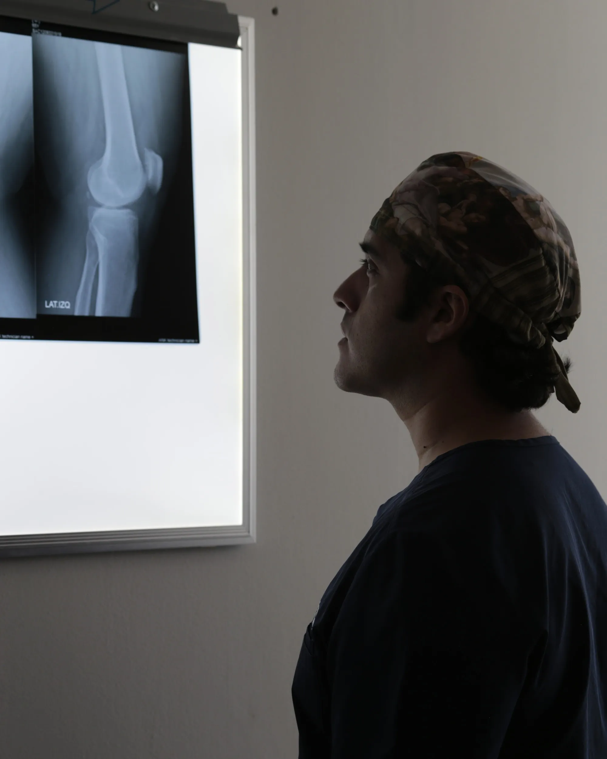 El Dr. Mauricio Céspedes revisando una radiografía de rodilla en el negatoscopio de su consultorio